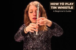 A woman holding a tin whistle-How to play Tin Whistle